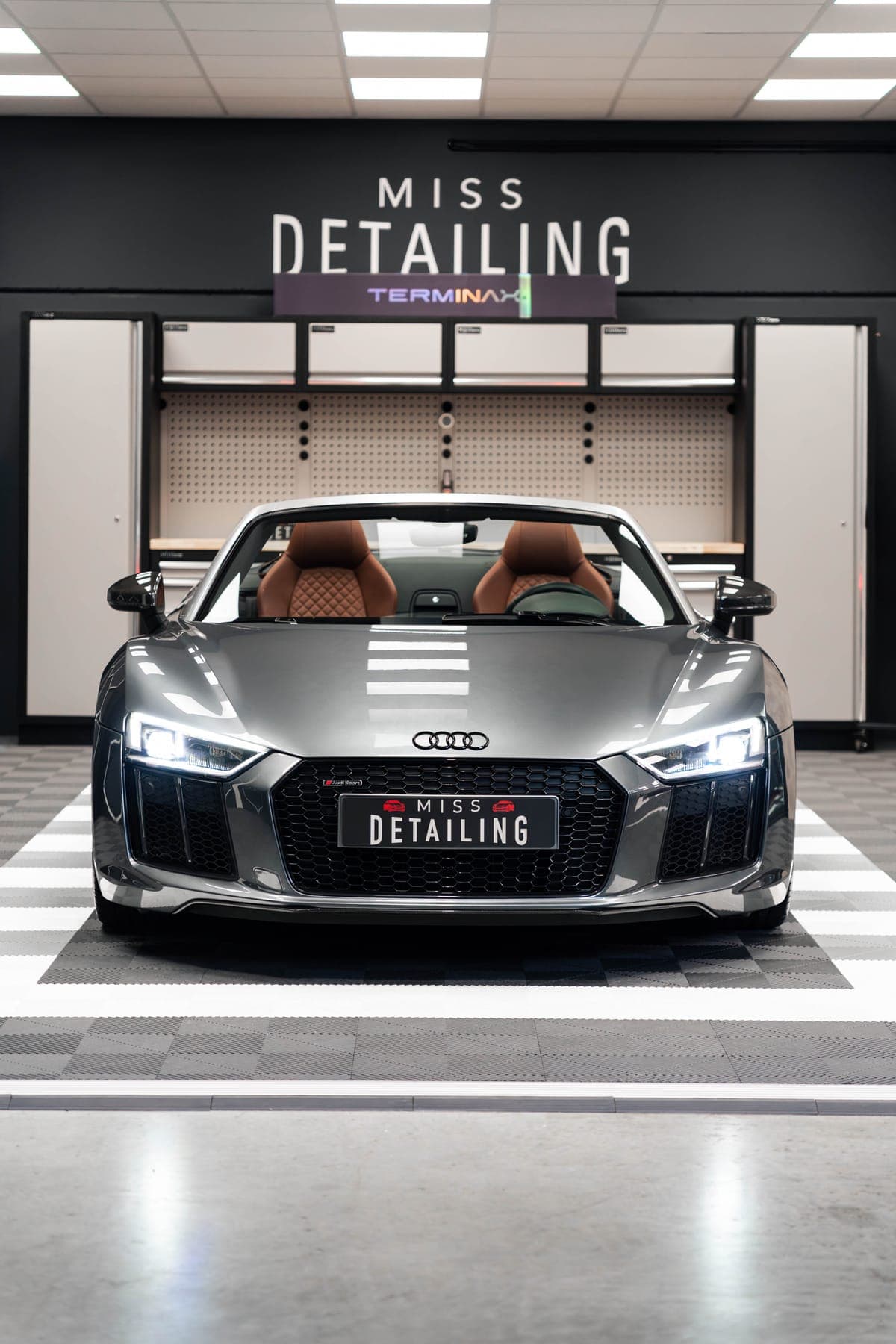 Audi R8 Spyder de face dans l'atelier Miss Detailing, enseigne au mur