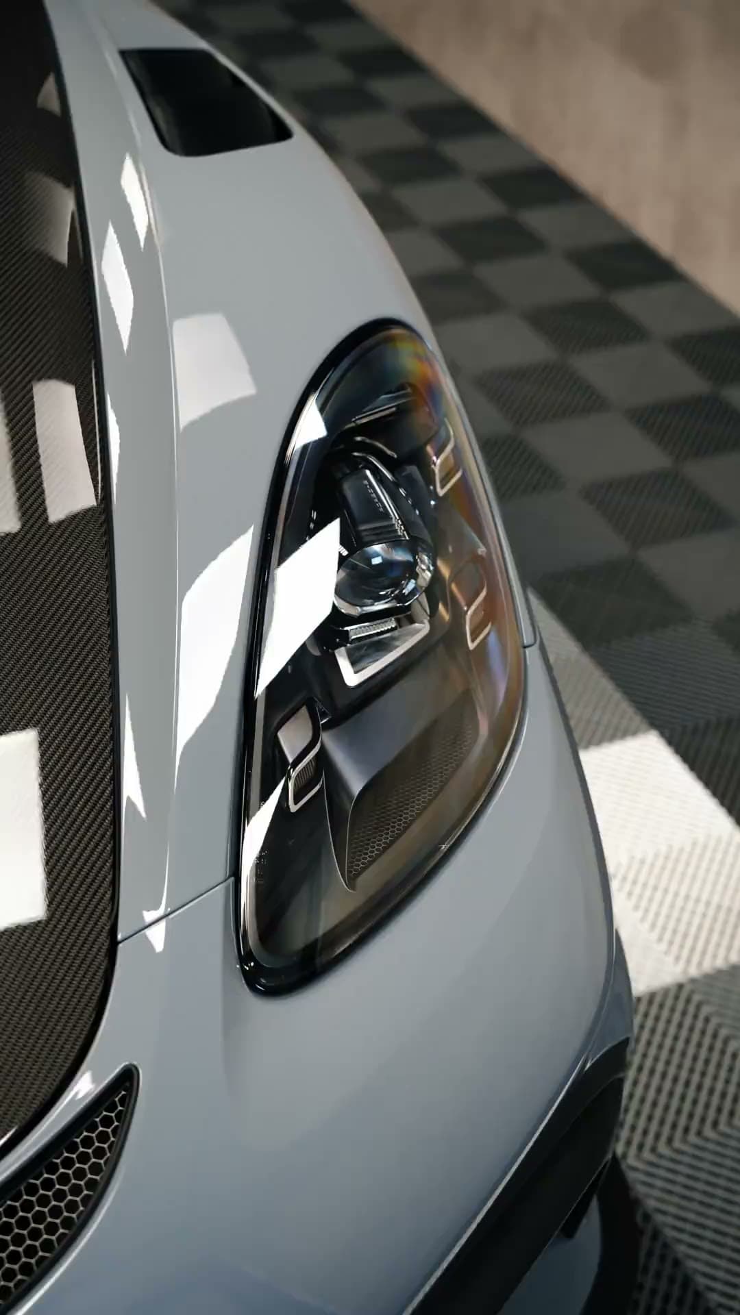 Phare avant d'une Porsche GT4 RS grise dans l'atelier Miss Detailing, première image de la vidéo de présentation